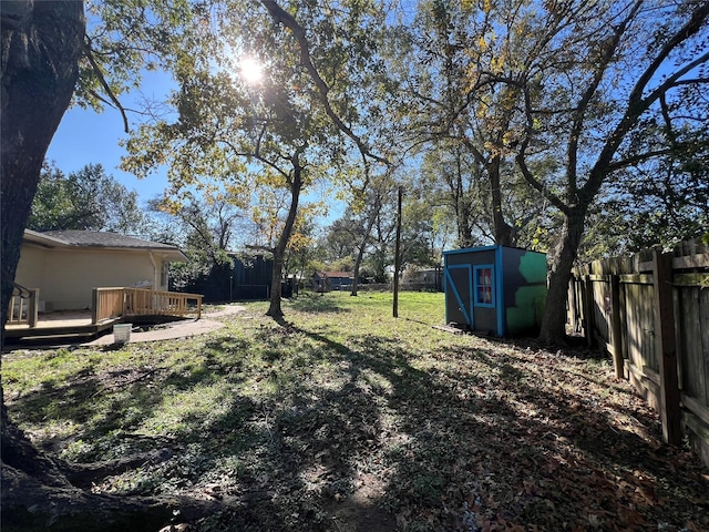 view of yard featuring a storage shed and a deck