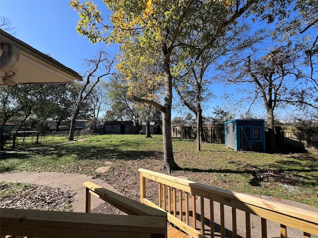 view of yard with a deck and a storage unit