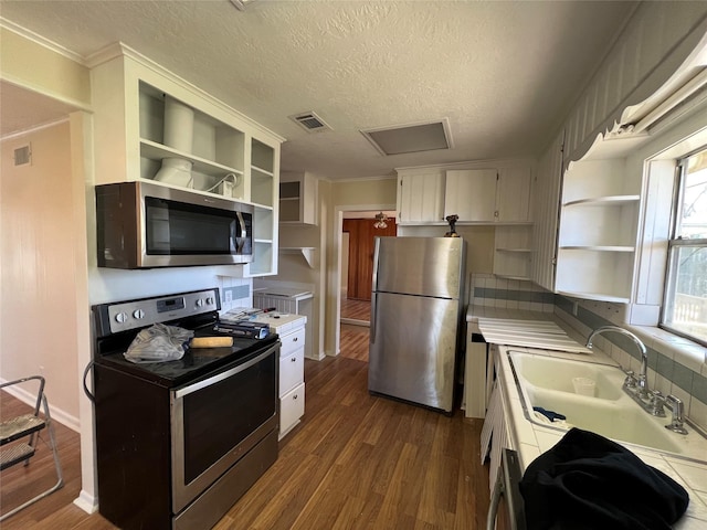 kitchen featuring sink, a textured ceiling, appliances with stainless steel finishes, hardwood / wood-style flooring, and white cabinets