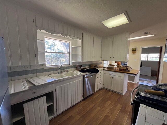 kitchen featuring dishwasher, sink, tile countertops, a textured ceiling, and white cabinets