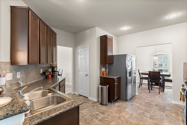 kitchen with a textured ceiling, stainless steel appliances, sink, and dark brown cabinetry