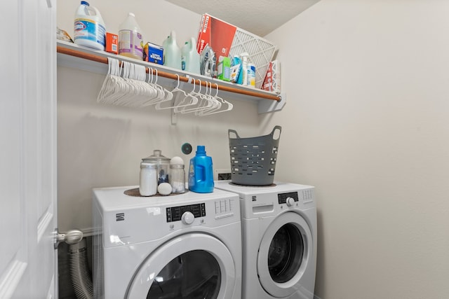 washroom featuring washing machine and clothes dryer and a textured ceiling