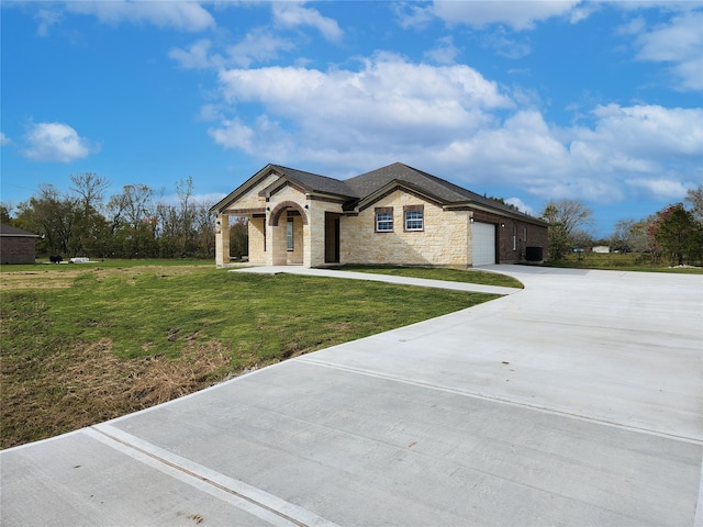 view of front of home featuring driveway, an attached garage, and a front lawn