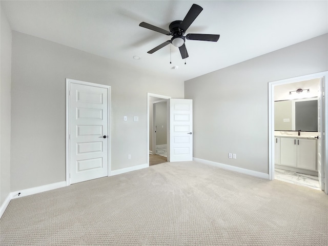 unfurnished bedroom featuring ceiling fan, light colored carpet, and ensuite bathroom