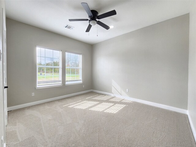 carpeted spare room with ceiling fan