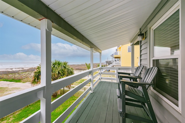 wooden terrace with a view of the beach and a water view