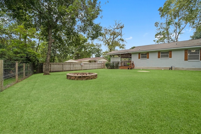 view of yard featuring an outdoor fire pit and a patio