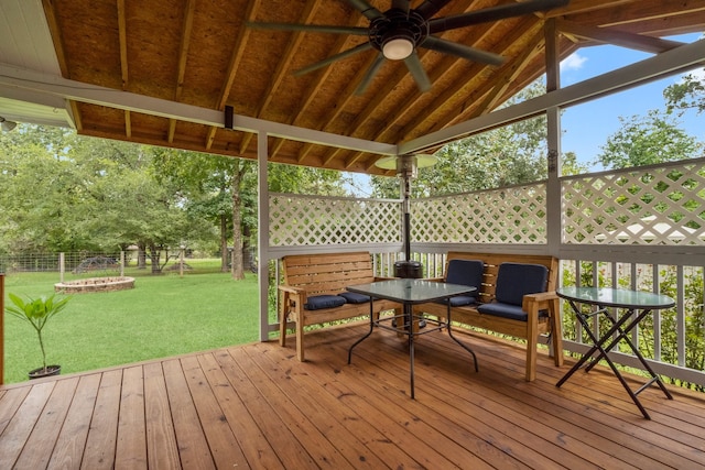 wooden terrace with ceiling fan and a yard