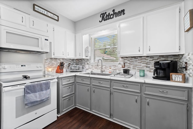 kitchen featuring gray cabinetry, white appliances, dark hardwood / wood-style flooring, backsplash, and sink