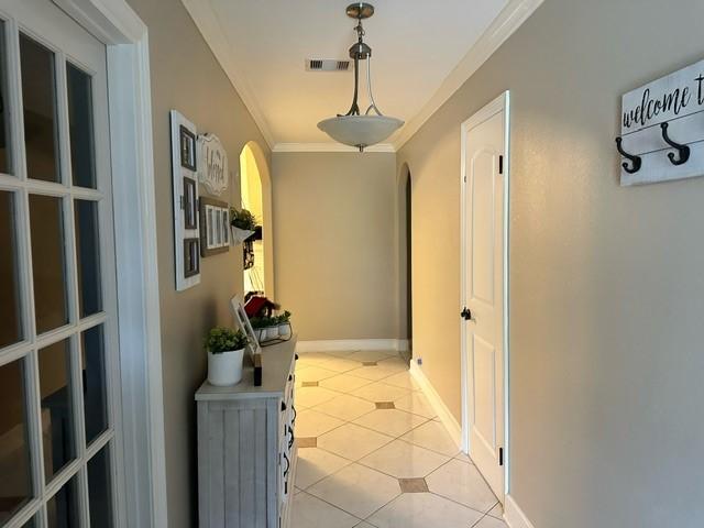 7410 Ashmole Ln, Houston, TX 77088 - corridor with arched walkways, light tile patterned floors, and ornamental molding