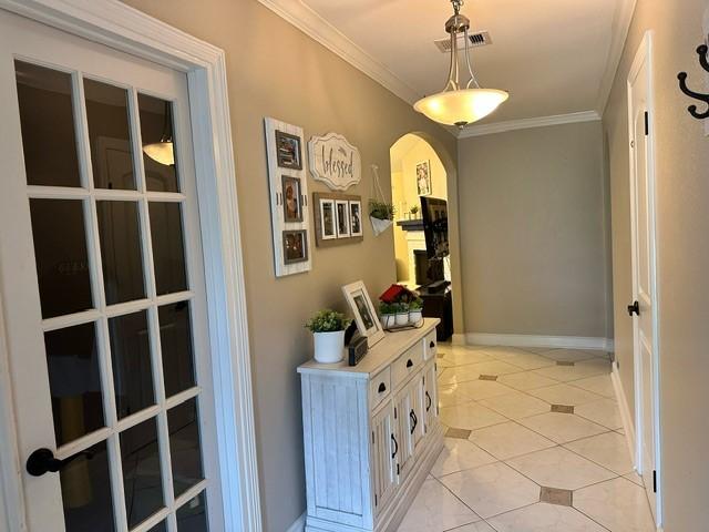 7410 Ashmole Ln, Houston, TX 77088 - corridor featuring crown molding, arched walkways, and light tile patterned flooring
