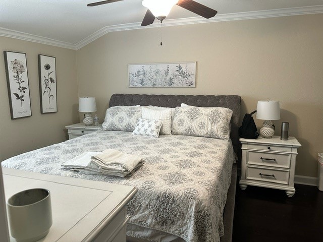 bedroom featuring lofted ceiling, ceiling fan, dark wood-type flooring, and crown molding