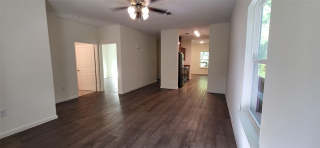 empty room with visible vents, dark wood-type flooring, and baseboards