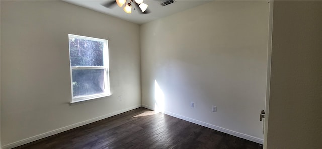 spare room with visible vents, baseboards, dark wood-type flooring, and ceiling fan