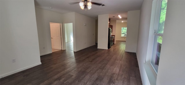 empty room with visible vents, baseboards, dark wood-type flooring, and a ceiling fan