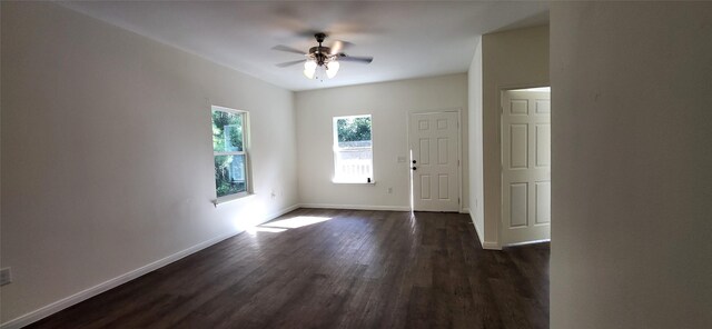 spare room with dark wood-style floors, baseboards, and ceiling fan