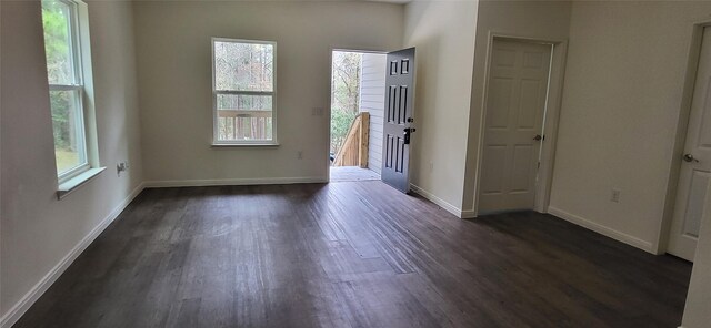 unfurnished room with dark wood-type flooring and baseboards