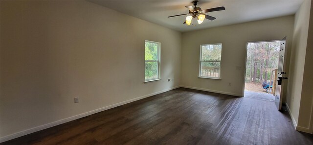 spare room with dark wood-style floors, a ceiling fan, and baseboards