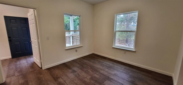 empty room with dark wood finished floors and baseboards