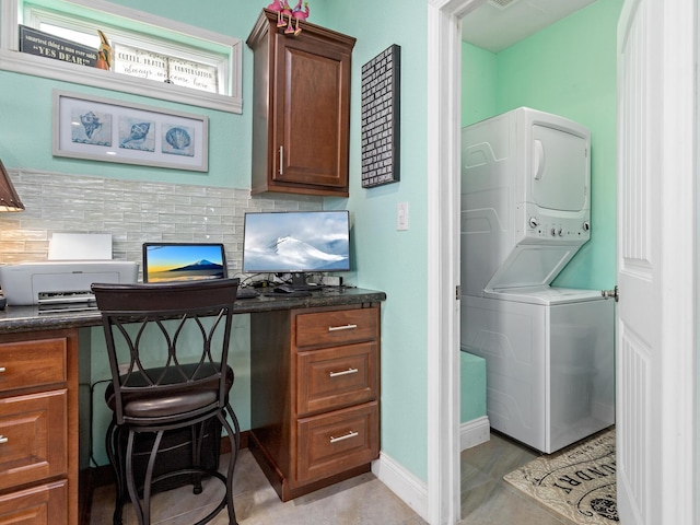 office area with stacked washing maching and dryer