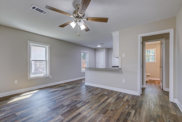 unfurnished living room featuring ceiling fan and dark wood-type flooring