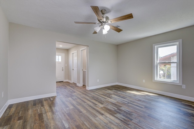 spare room with dark wood-type flooring and ceiling fan