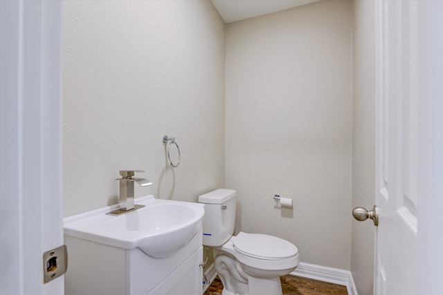 bathroom with vanity, hardwood / wood-style floors, and toilet