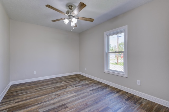 empty room with ceiling fan and dark hardwood / wood-style flooring