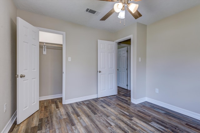 unfurnished bedroom with a closet, ceiling fan, dark hardwood / wood-style floors, and a textured ceiling