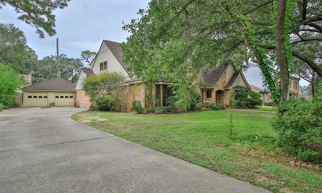 view of front of property with a garage, a front lawn, and an outbuilding