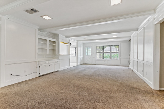 unfurnished living room featuring ornamental molding, light carpet, and beam ceiling