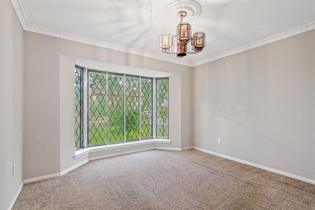 empty room featuring ornamental molding, a chandelier, and carpet floors