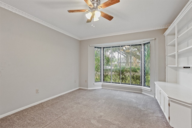 unfurnished room featuring crown molding, light colored carpet, and ceiling fan