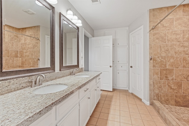 bathroom with vanity, tile patterned floors, and a tile shower