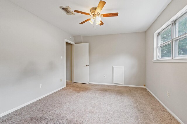 empty room featuring ceiling fan and light carpet