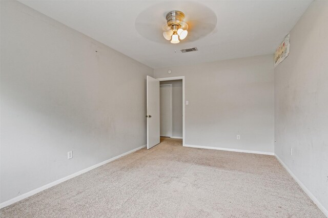 carpeted spare room with ceiling fan