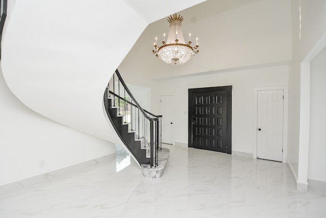 foyer entrance featuring an inviting chandelier and a towering ceiling