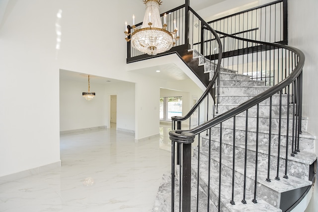 stairs with an inviting chandelier and a towering ceiling