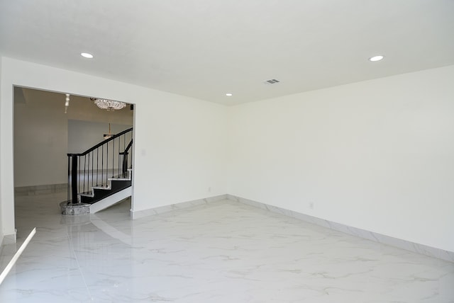 unfurnished room with an inviting chandelier