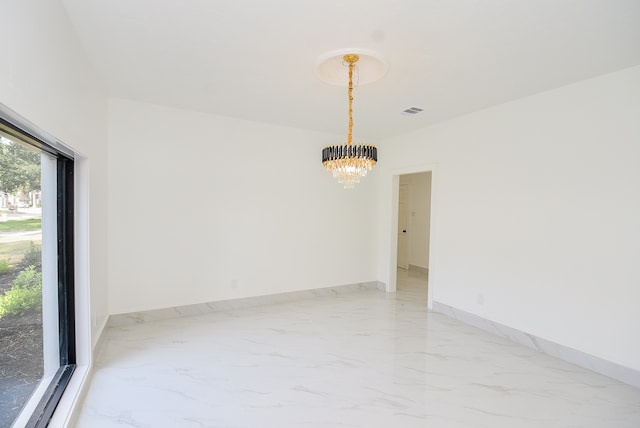 unfurnished room featuring a notable chandelier