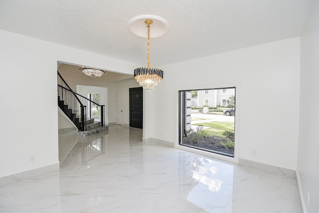 unfurnished room featuring an inviting chandelier