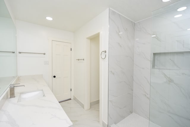 bathroom featuring tiled shower and vanity