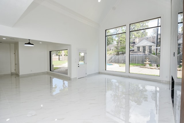 unfurnished room with crown molding, plenty of natural light, and high vaulted ceiling