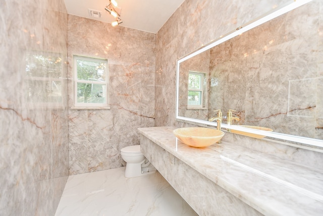 bathroom featuring tile walls, toilet, plenty of natural light, and vanity