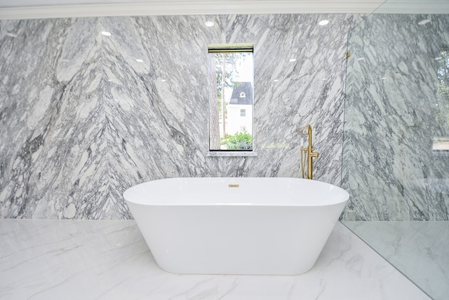 bathroom with tile walls and a bath