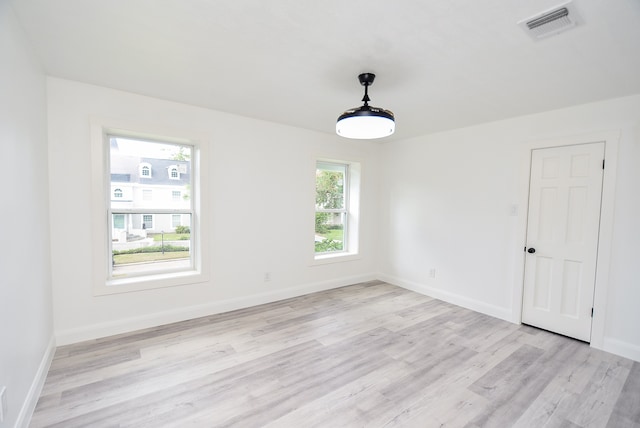 empty room featuring plenty of natural light and light hardwood / wood-style flooring