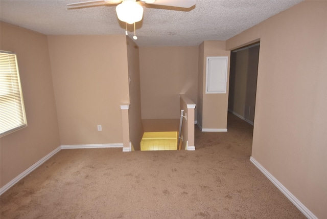 empty room with a textured ceiling, baseboards, and carpet floors