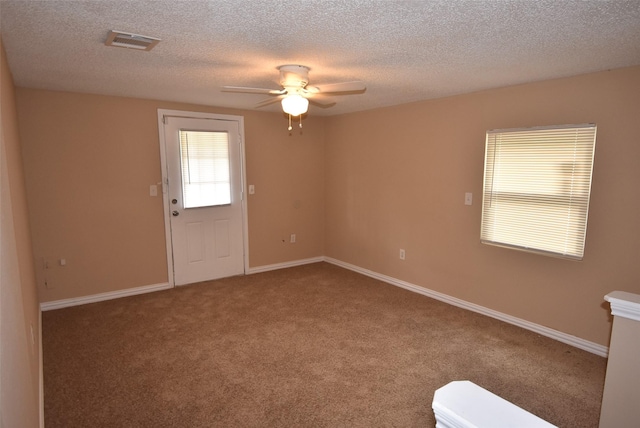 spare room with baseboards, carpet, visible vents, and ceiling fan