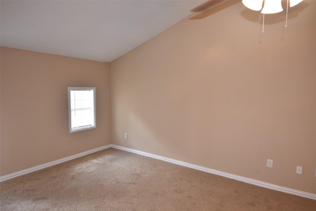 spare room featuring a ceiling fan, lofted ceiling, carpet, and baseboards