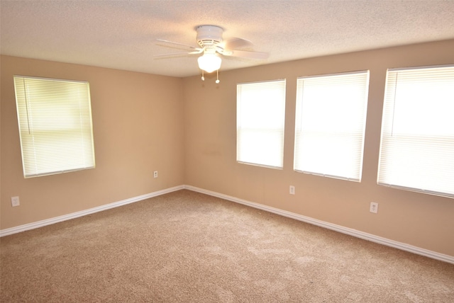 carpeted spare room with baseboards, a textured ceiling, and ceiling fan